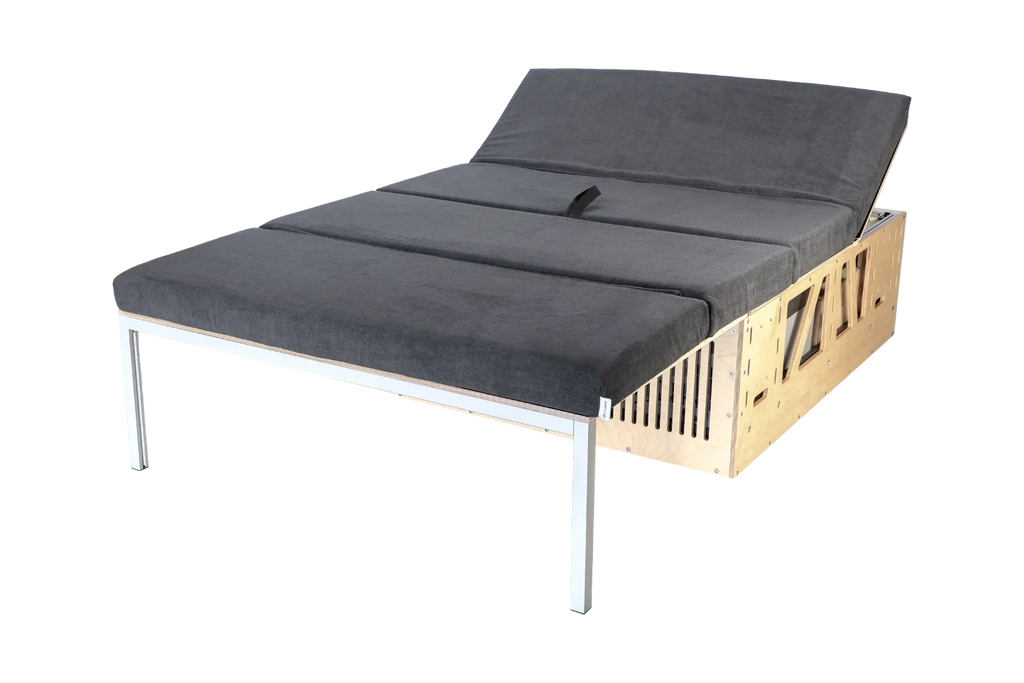 CampBoks® Pro 2.0 als ausgeklapptes Bett mit grauen Polstern und angehobener Kopfstütze.